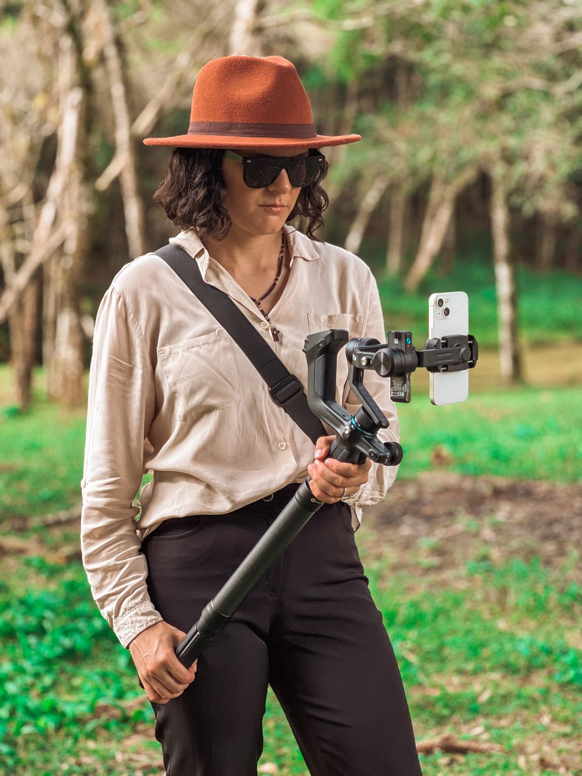Nay, editora, segurando o gimbal com celular usado nas coberturas